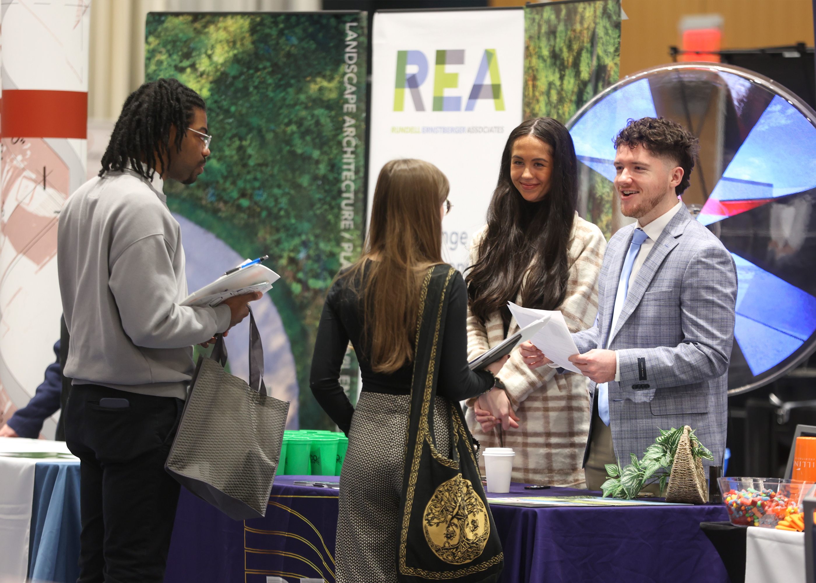 Photograph of two students talking to firm representatives at the 2025 Design Career Fair.