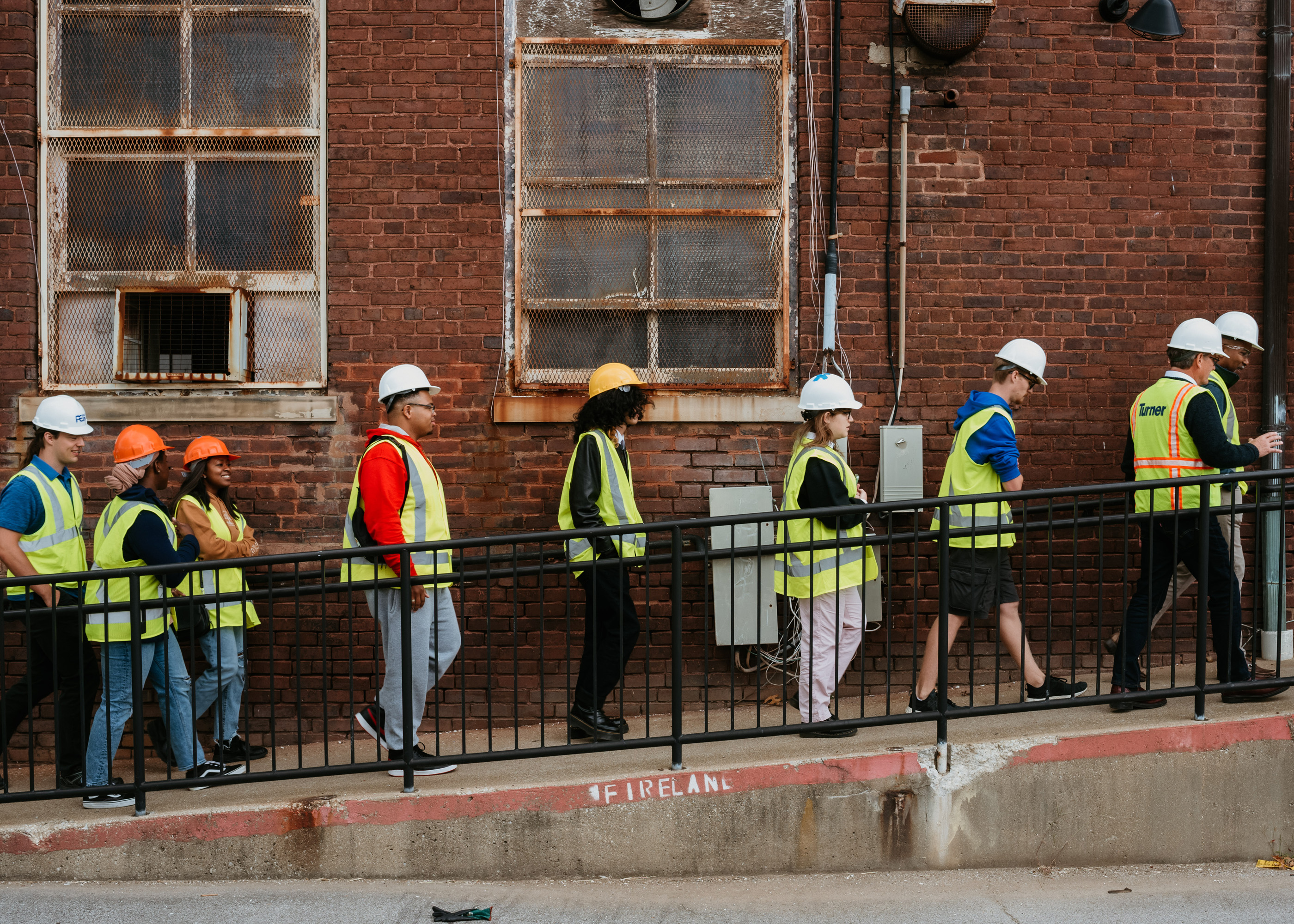 photograph of students walking into a hard hat tour of our new building