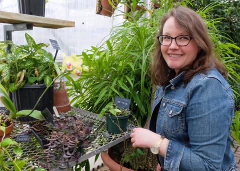 Photograph of Christina Wilson in a greenhouse