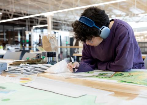 Photograph of a first year student working on a plan in the Gray Design Building.
